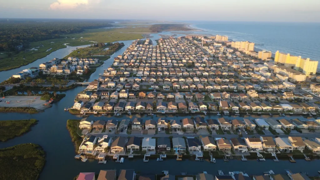 Aerial view of Cherry Grove in North Myrtle Beach, showcasing coastal homes and waterways at sunset.